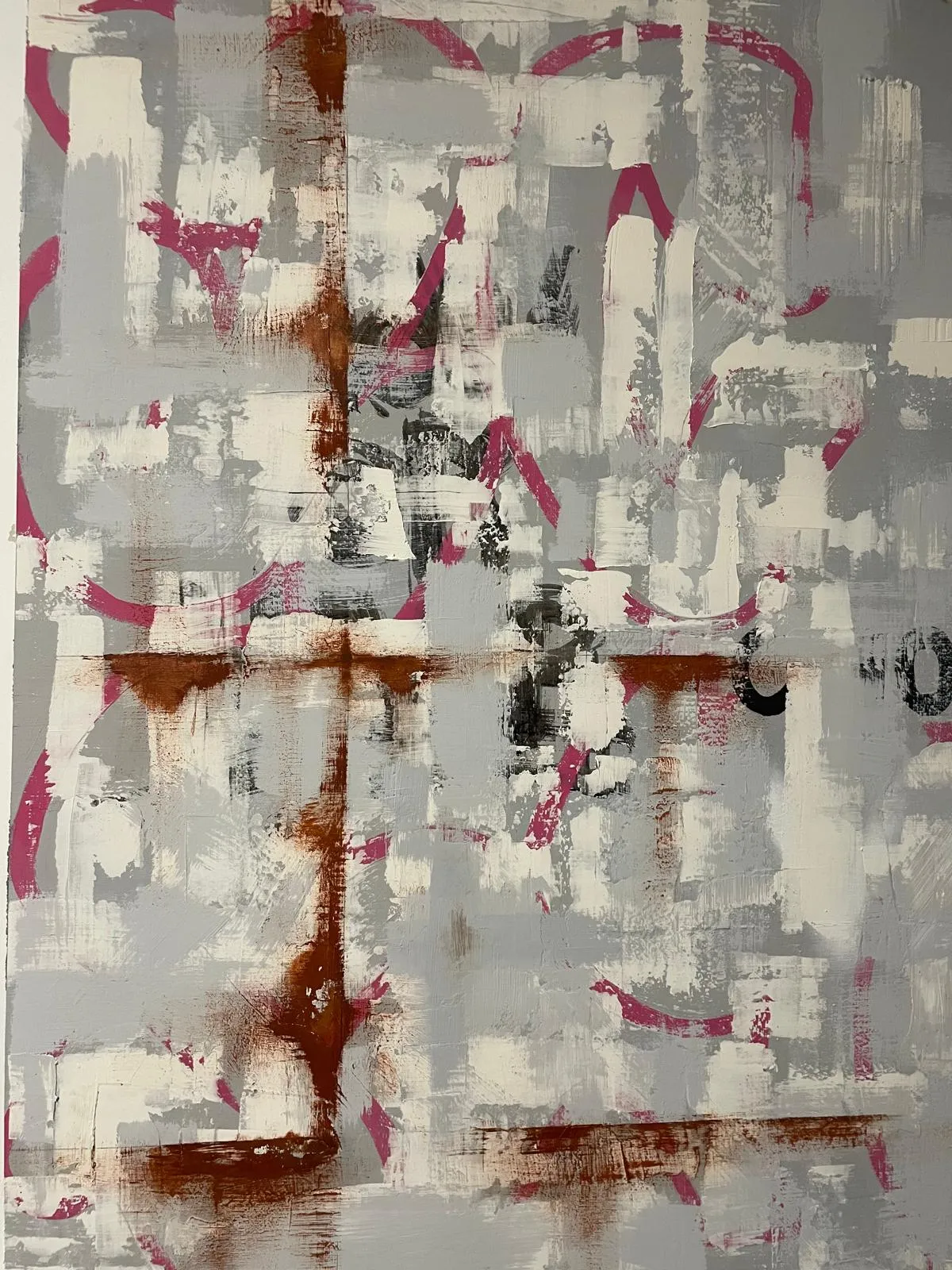A large wall painted in overlapping blocks of grey and white with magenta and rust bleeding through, and stencilled black lettering half buried under the top coat.
