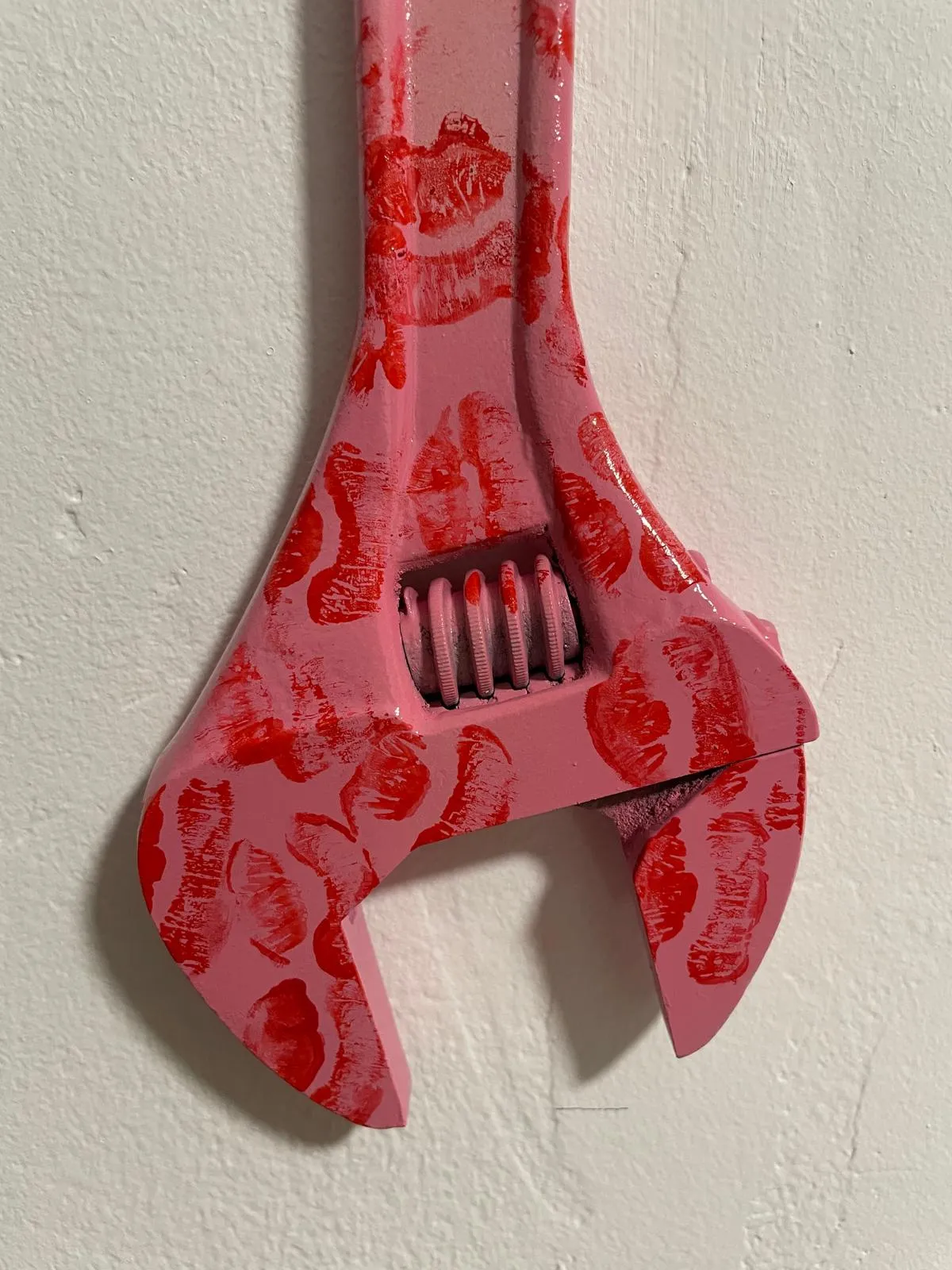 Detail of the jaw: overlapping red lipstick prints across the pink enamel, each one showing the ridges of the lips.